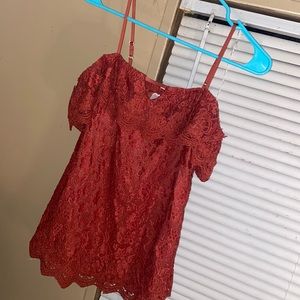 A rust type of color off the shoulder shirt